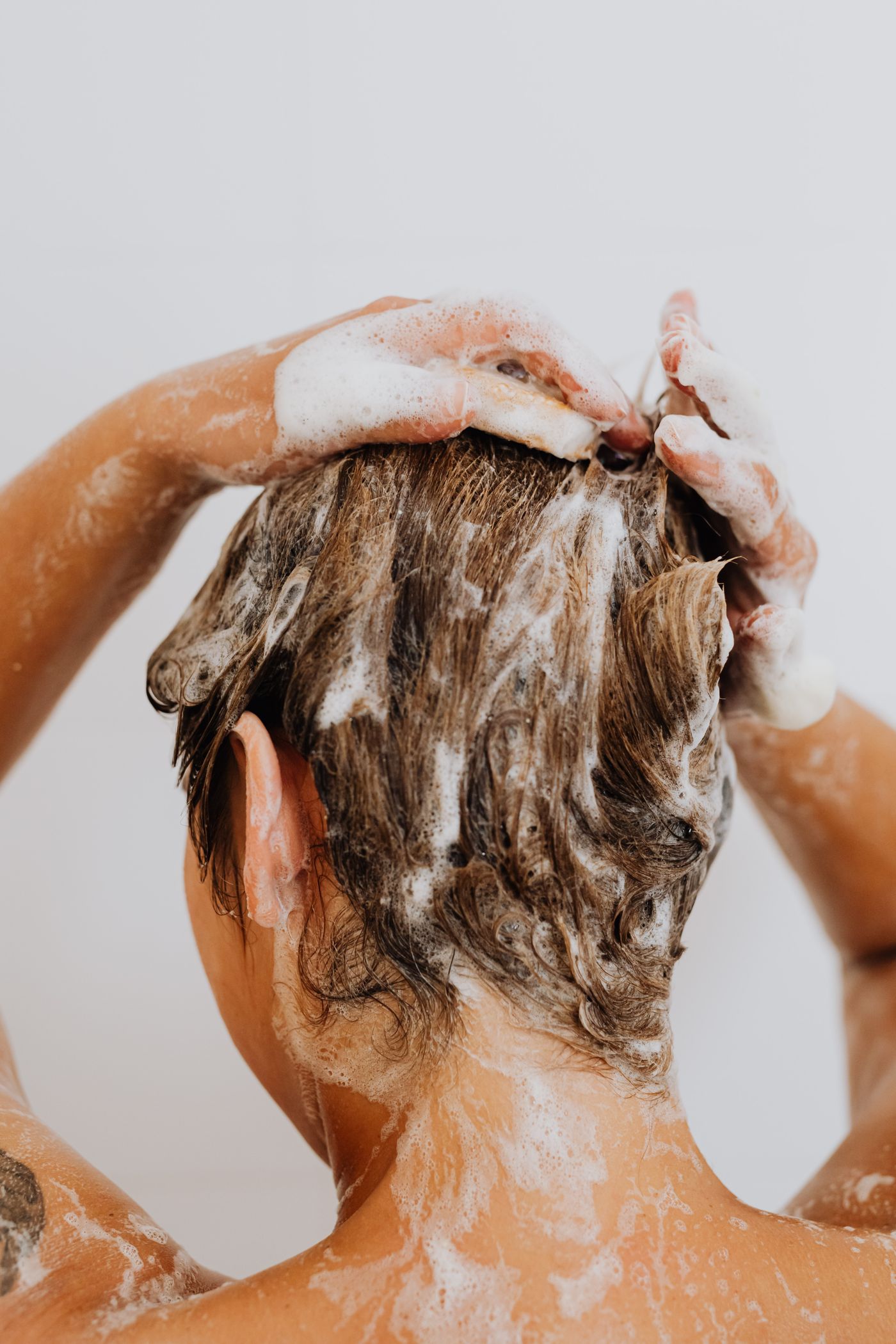 Hände in eingeschäumten Haaren