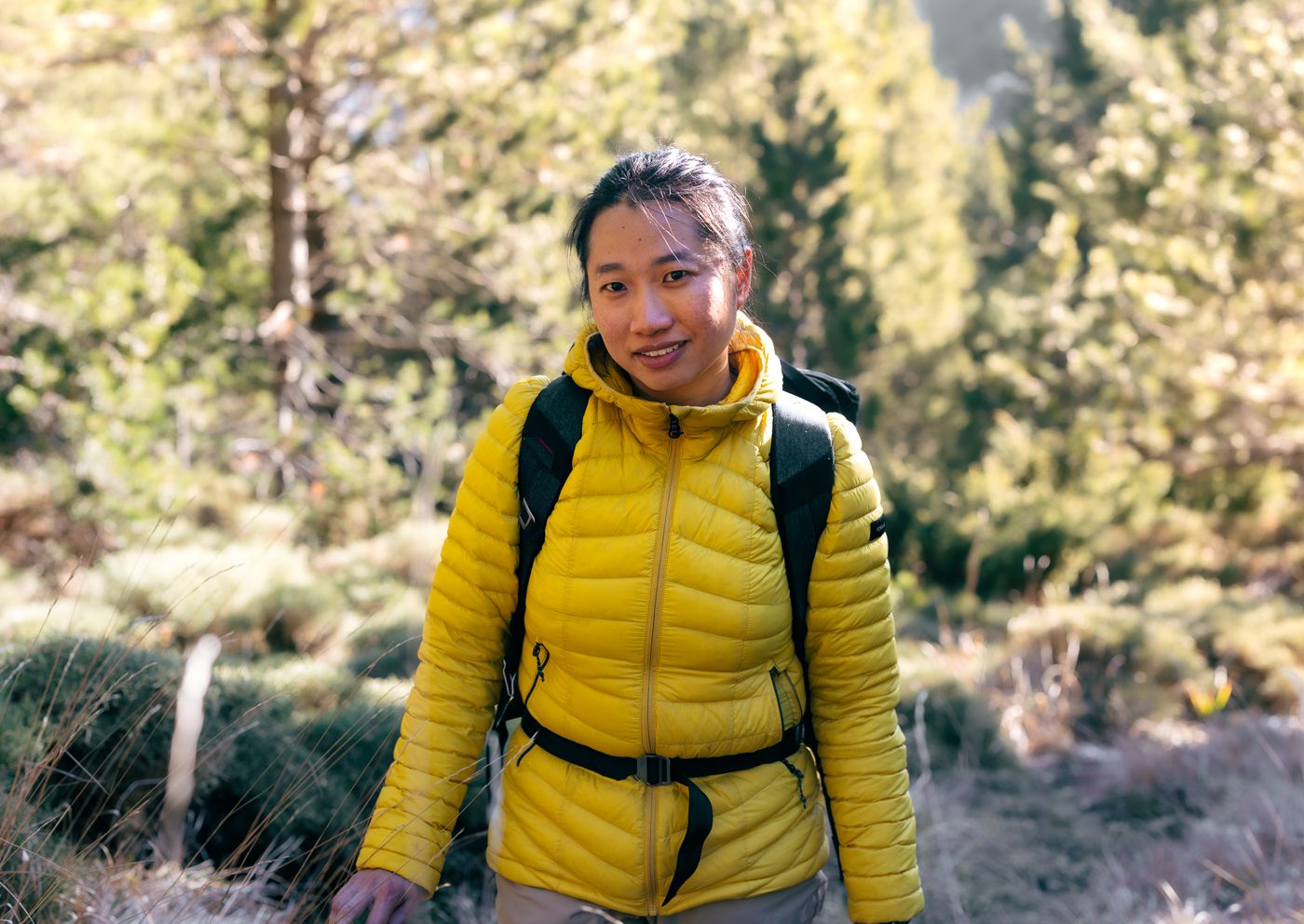 Frau mit Rucksack beim Wandern im Wald